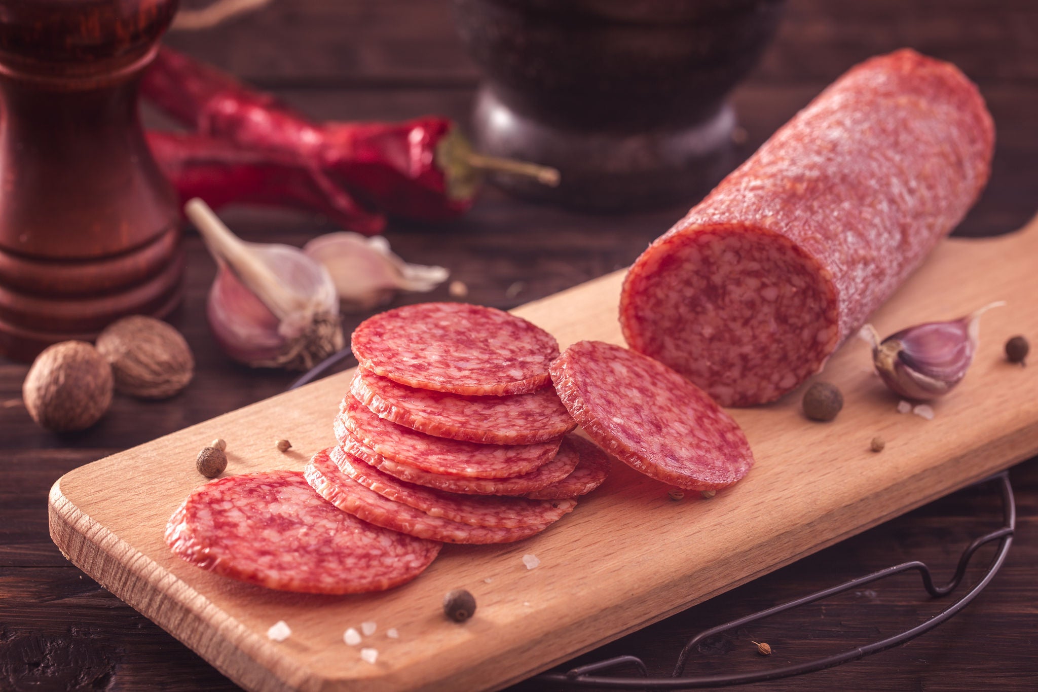 Sliced salami on cutting board.Toned